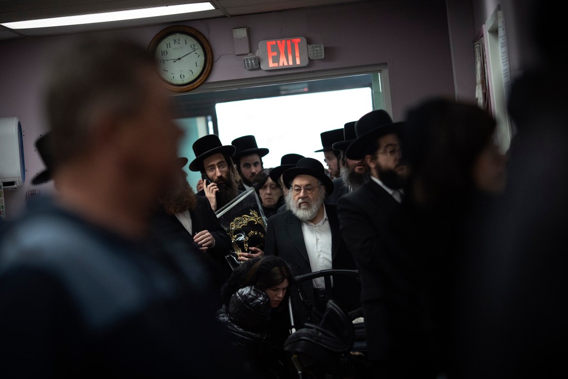 Members of the Orthodox Jewish community stand in line to register to vote at a polling center.