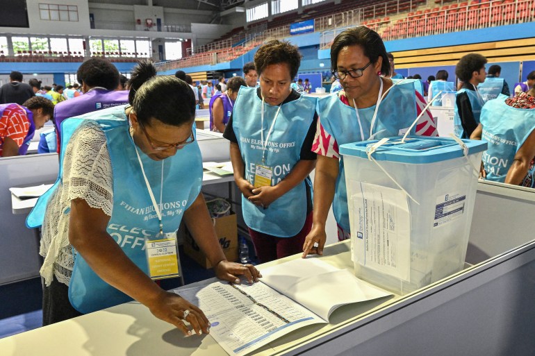 Election Commission officials prepare to open the ballot boxes for counting during Fiji's general election in the capital city Suva on December 14,