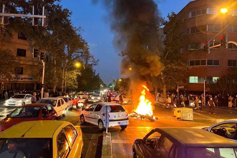 A vehicle burns during protests in Tehran