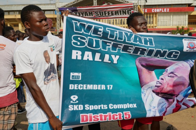 Demonstrators hold a banner as they protest over the ongoing economic hardship and President George Weah's prolonged absence from the country, in Paynesville, a suburb of Monrovia, Liberia