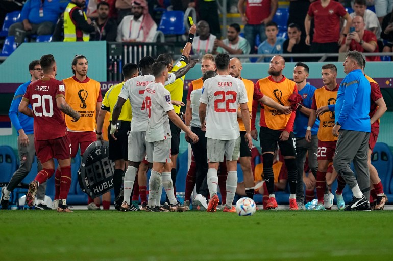 Serbian players from the bench argue with Switzerland players after Serbia's goalkeeper Predrag Rajkovic received a yellow card during the World Cup group G soccer match between Serbia and Switzerland, at the Stadium 974 in Doha, Qatar, Friday, Dec. 2, 2022. (AP Photo/Ebrahim Noroozi)