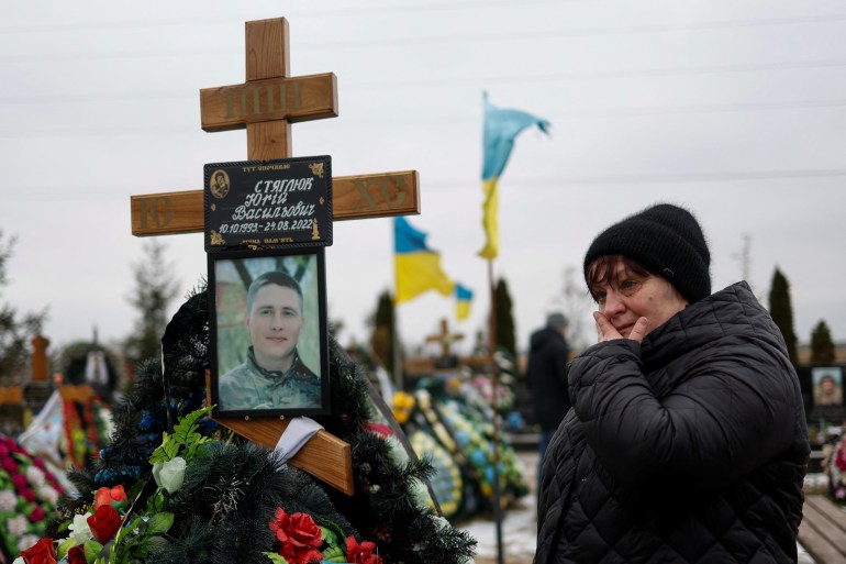 Local resident Olha reacts as she visits the grave of her son Yuri Stiahliuk, a Ukrainian service member