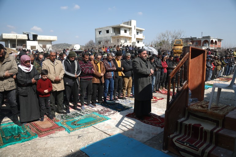 Imam Adel al-Sheikh leads the Friday prayer in a rubble-strewn open lot