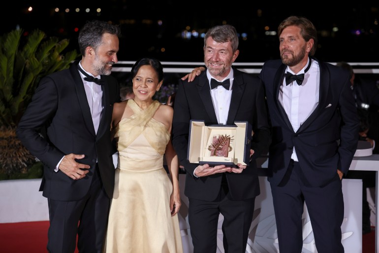 Erik Hemmendorff, from left, Dolly De Leon, Philippe Bobe, director Ruben Ostlund pose with the Palm d'Or Award for 