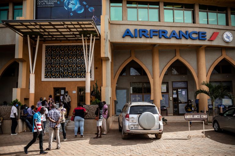 People queue at the office of French airline Air France in Ouagadougou Wednesday Jan. 26, 2022