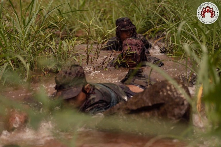 Soldiers from the BPLA take part in sniper training. There are moving through grases and water on their stomachs.