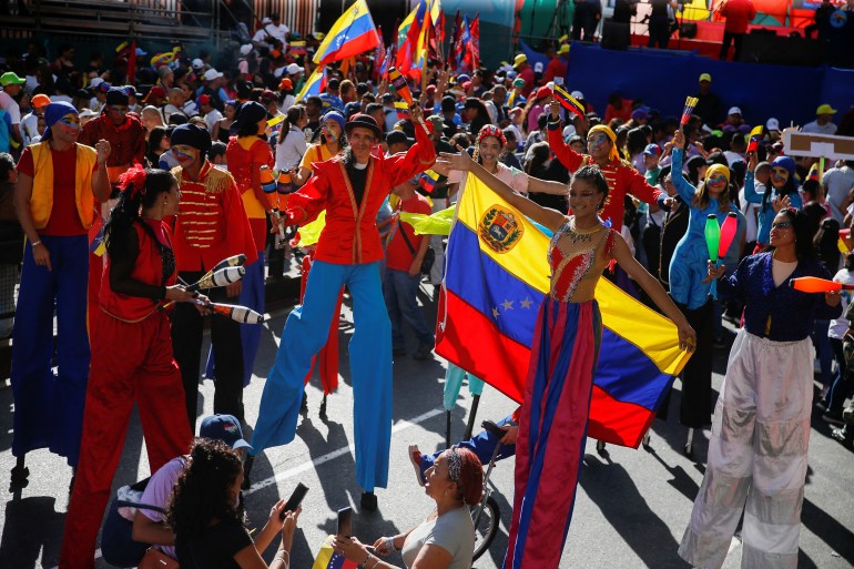 Supporters of Venezuelan President Nicolas Maduro stand on stilts,