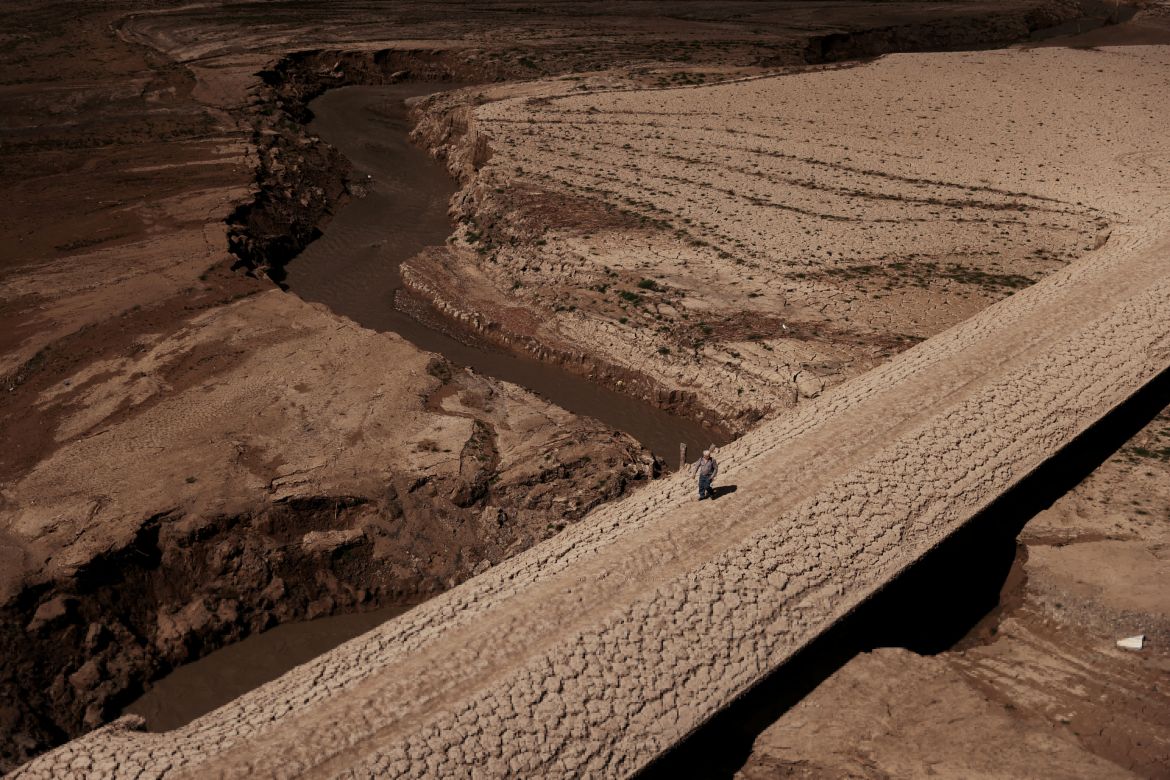 A man walks on the cracked ground of the Baells reservoir as drinking water supplies have plunged to their lowest level since 1990 due to extreme drought in Catalonia, in the village of Cersc, in the region Bergueda, Spain.