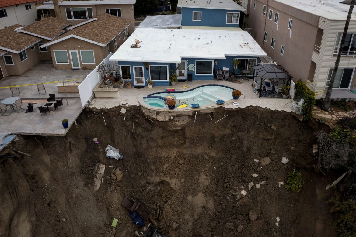 A backyard pool is left hanging on a cliffside after torrential rain brought havoc on the beachfront town of San Clemente, California, U.S.