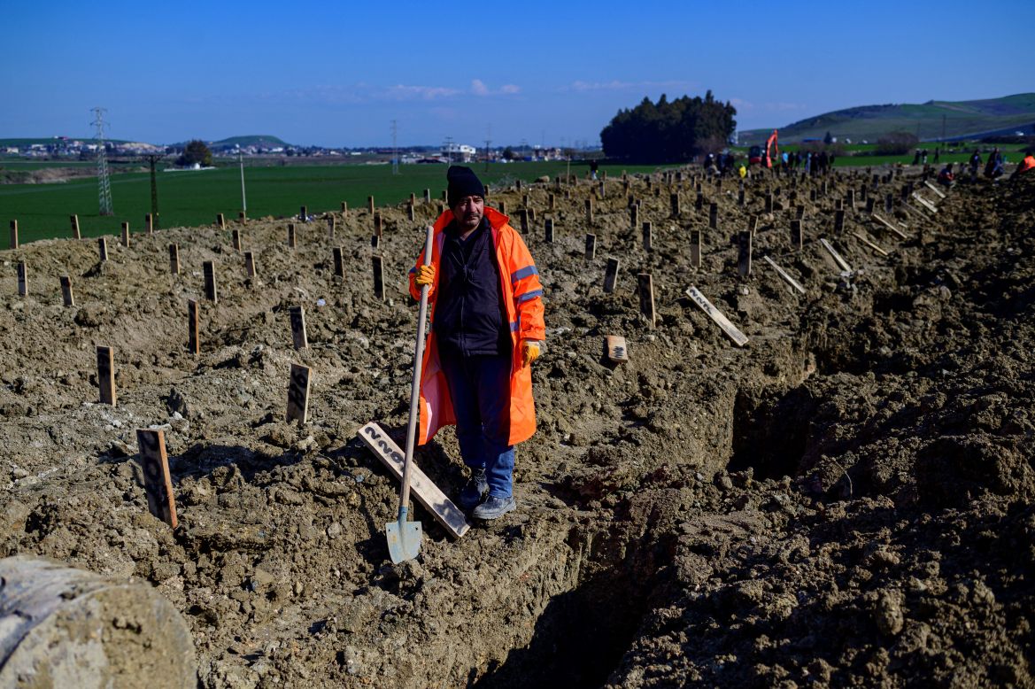 A city employee dig graves in a mass grave area following an earthquake in Hatay, on February 10, 2023.