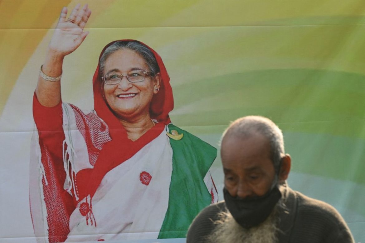A man walks past a poster of the Awami League party featuring their leader and Bangladesh's Prime Minister Sheikh Hasina in Dhaka on January 5, 2024.