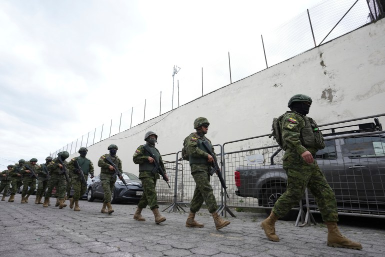 Police and soldiers prepare to enter El Inca prison to quell a riot in Quito, Ecuador