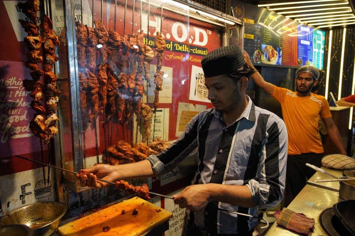 Chicken meat is arranged on a rod for roasting. [Meer Faisal/Al Jazeera]