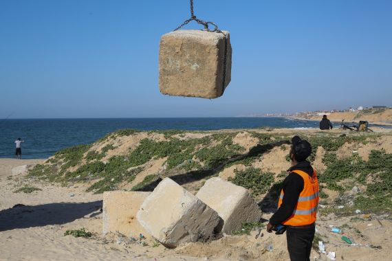 Palestinian workers move concrete blocks to be used in building temporary pier, amid the ongoing conflict between Israel and Hamas, in Khan Younis on the southern Gaza Strip, March 12, 2024. REUTERS/Ahmed Zakot