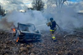 A firefighter extinguishes fire in a car destroyed during a Russian missile strike, amid Russia's attack on Ukraine, in Mykolaiv, Ukraine