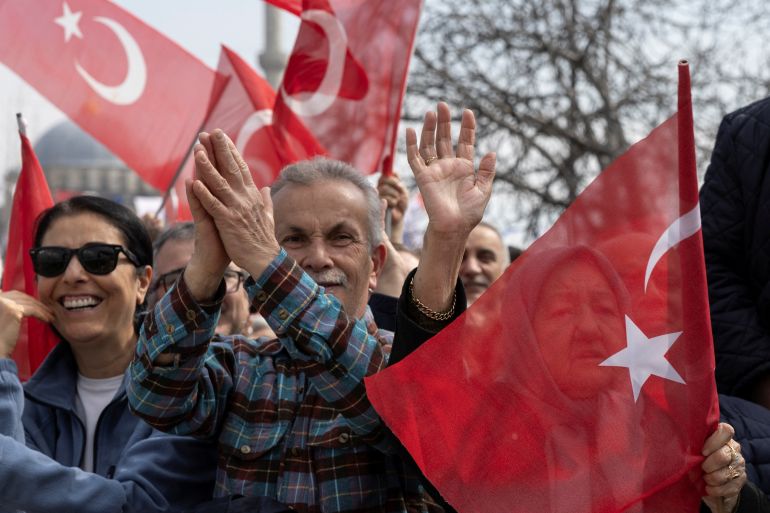 Supporters of Istanbul's mayor Ekrem Imamoglu wave Turkish flags during a campaign event ahead of the local elections in Istanbul, Turkey, March 19, 2024.