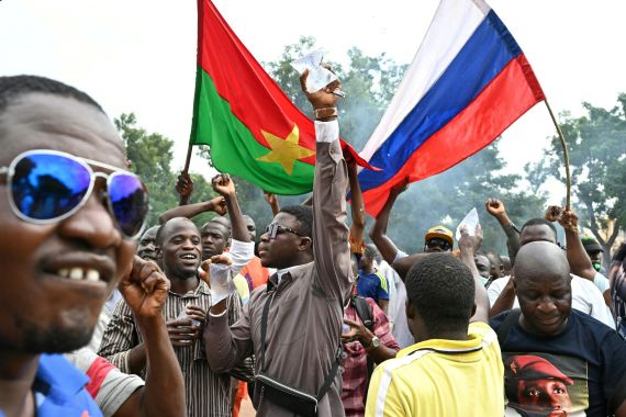 Supporters of Burkina Faso's military government leader, Ibrahim Traore, hold the national flags of Burkina Faso and Russia during a demonstration in Ouagadougou on October 6, 2022