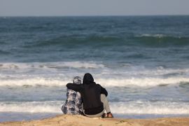 A couple watches the waves at the beach near a makeshift tent camp for displaced Palestinians in Rafah near the border with Egypt in the southern Gaza Strip, on January 24, 2024 amid the ongoing conflict between Israel and the Palestinian militant group Hamas. (Photo by AFP)