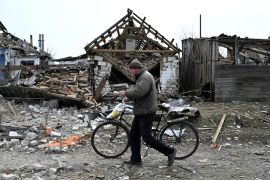 A man walks past destroyed homes in Velyka Pysarivka, which lies just five kilometres from the Russian border, in Sumy region. [Genya Savilov/AFP]