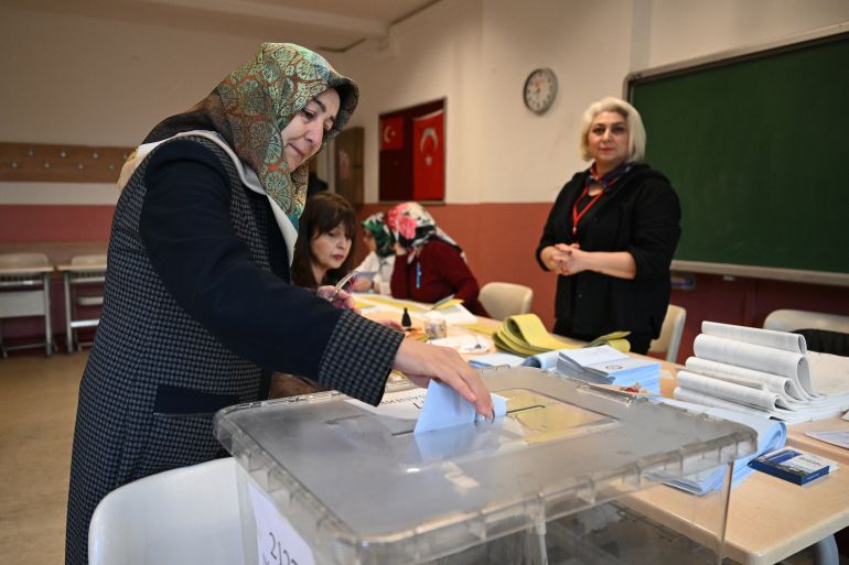 A woman casts her vote during the Turkish municipal elections, in Istanbul on March 31, 2024. - Turkish citizens head to the polls on March 31, 2024, in local elections as the President sets his sights on winning back Istanbul, the country's economic powerhouse, after he was re-elected head of state in a tight contest last year. The latest elections come in the throes of an economic crisis that saw the inflation rate surge to 67.1 percent and the Turkish currency crumble against dollar. (Photo by OZAN KOSE / AFP)