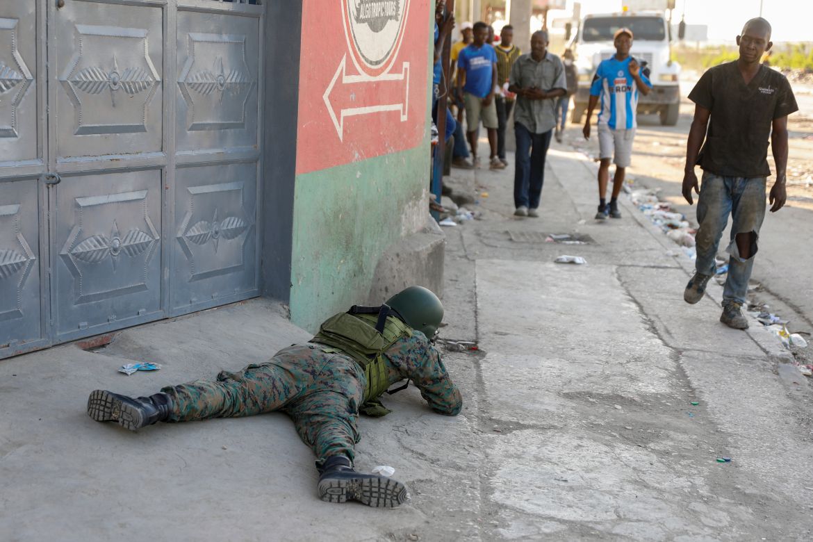 Pedestrians was past a soldier guarding the area of the international airport in Port-au-Prince,