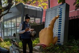 A man walks past a large model of a woman&#039;s finger pressing a button of an electronic voting machine displayed outside the office of Election Commission of India in New Delhi, India, Wednesday, March 20, 2024. From April 19 to June 1, more than 10 percent of humanity will vote in the world&#039;s biggest election ever [Altaf Qadri/AP Photo]