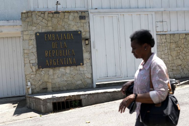 A woman walks in front of the outer wall of the Argentine embassy in Caracas, Venezuela.