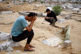 The uncle of Sabreen al-Rouh, a Palestinian baby girl, who died a few days after she was saved from the womb of her dying mother Sabreen al-Sakani, crouches next to the child&#039;s grave in Rafah in the southern Gaza Strip, on April 26, 2024 [Mohammed Salem/Reuters]