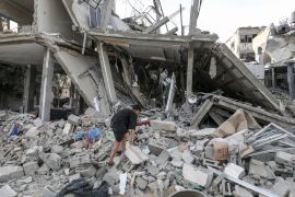 Palestinians examine the destroyed and damaged buildings in Rafah [Abed Rahim Khatib/Anadolu]