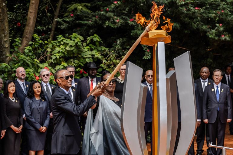 TOPSHOT - President of Rwanda Paul Kagame (C L) and his wife Jeannette Kagame (C R) light a remembrance flame surrounded by heads of state and other dignitaries as part of the commemorations of the 30th Anniversary of the 1994 Rwandan genocide at the Kigali Genocide Memorial in Kigali on April 7, 2024. Rwanda on Sunday paid solemn tribute to genocide victims, 30 years after a vicious campaign orchestrated by Hutu extremists tore apart the country, as neighbours turned on each other in one of the bloodiest massacres of the 20th century. The killing spree, which lasted 100 days before the Rwandan Patriotic Front (RPF) rebel militia took Kigali in July 1994, claimed the lives of around 800,000 people, largely Tutsis but also moderate Hutus. (Photo by LUIS TATO / AFP) RELATED CONTENT