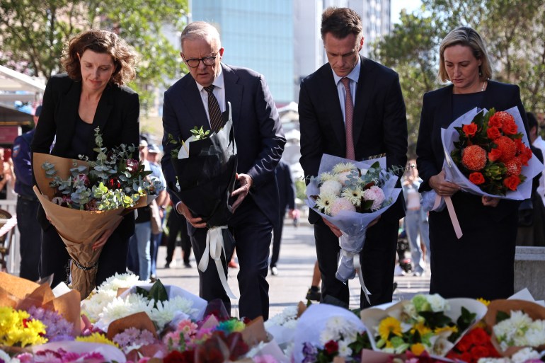 people in suits lay flowers