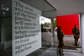 Italian soldiers stand guard in front of Israel&#039;s pavilion during the pre-opening of the Venice Biennale art fair [Gabriel Bouys/AFP]