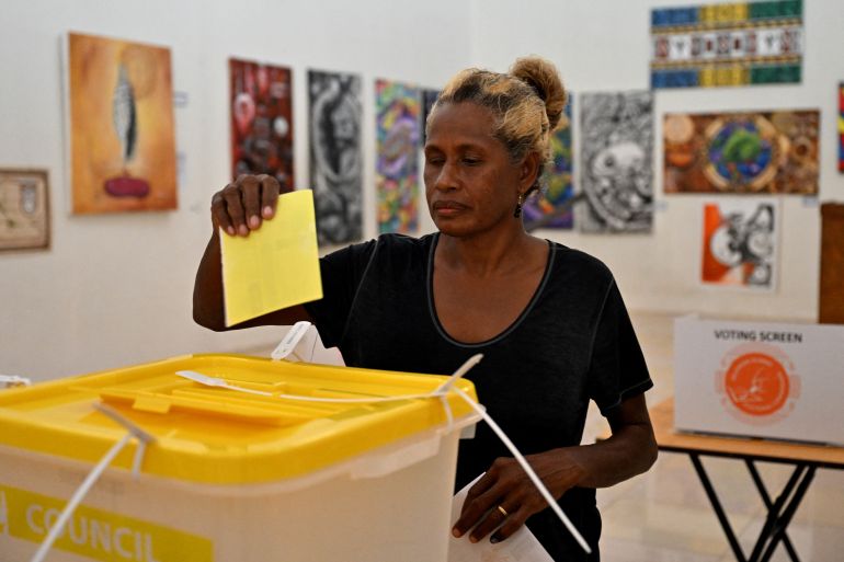 A woman drops her ballot paper into the box as general elections polling starts in Honiara, capital city of the Solomon Islands, on April 17, 2024.