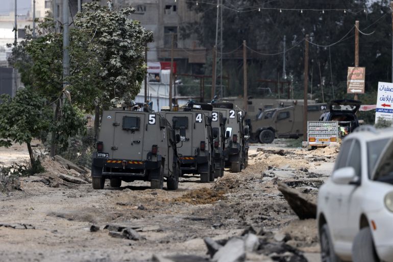 Israeli military vehicles drive along a devastated street in the Nur Shams refugee camp in the occupied West Bank, during a raid on April 19, 2024. (Photo by JAAFAR ASHTIYEH / AFP)