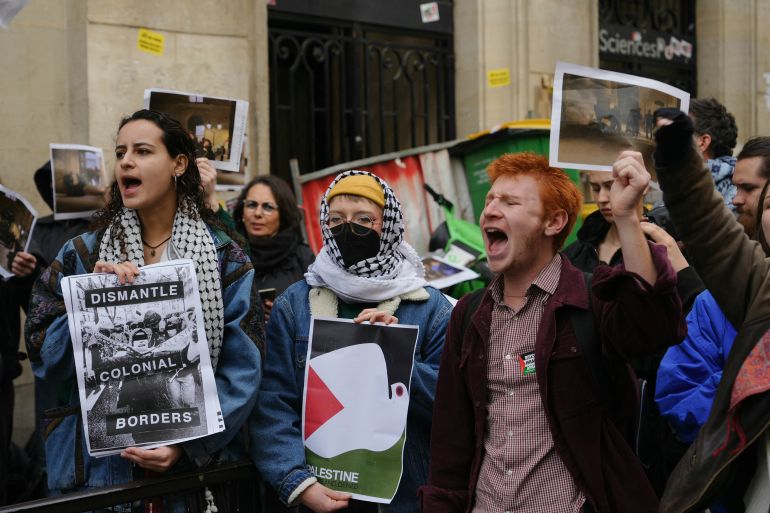 Demonstrators hold posters reading "dismantle colonial borders" as students occupy a building of the Institute of Political Studies (Sciences Po Paris) in support of Palestinians, in Paris