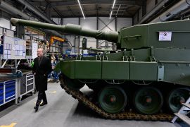 German Chancellor Olaf Scholz visits a production line at the future site of an arms factory where weapons maker Rheinmetall plans to produce artillery from 2025, in Unterluss, Germany [File: Fabian Bimmer/AP]
