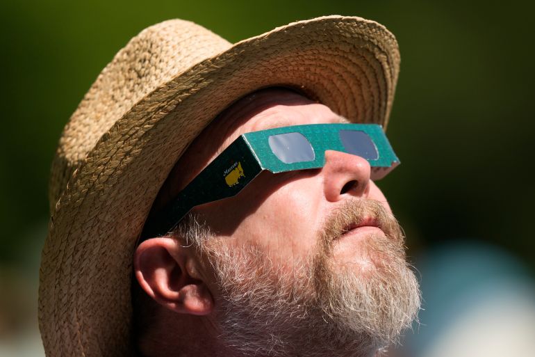 A bearded man stares upwards to watch the solar eclipse.