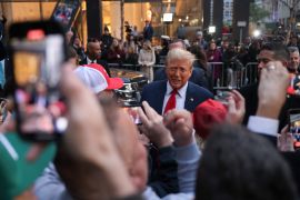 Former US President Donald Trump signs autographs and speaks with construction workers before appearing in court in New York on April 25, 2024 [Yuki Iwamura/The Associated Press]