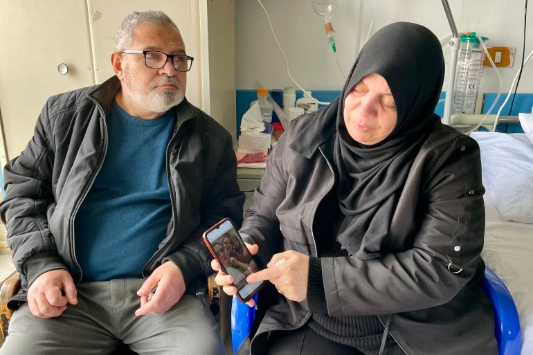 Hanan and Mazen in hospital room, Hanan showing photos of kids on the phone
