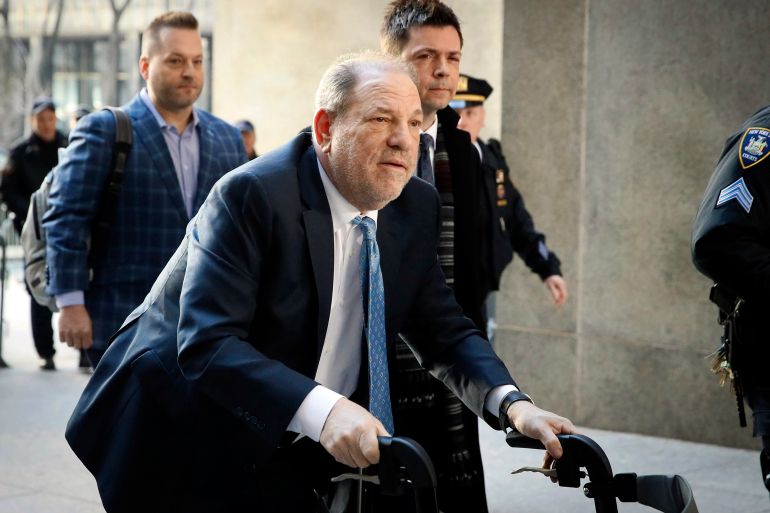 Weinstein arrives at a courthouse with a supporting wheeler