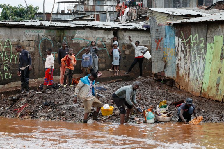 Residents wash their belongings recovered from their flooded house after the Nairobi river burst its banks within the Mathare valley settlement in Nairobi, Kenya