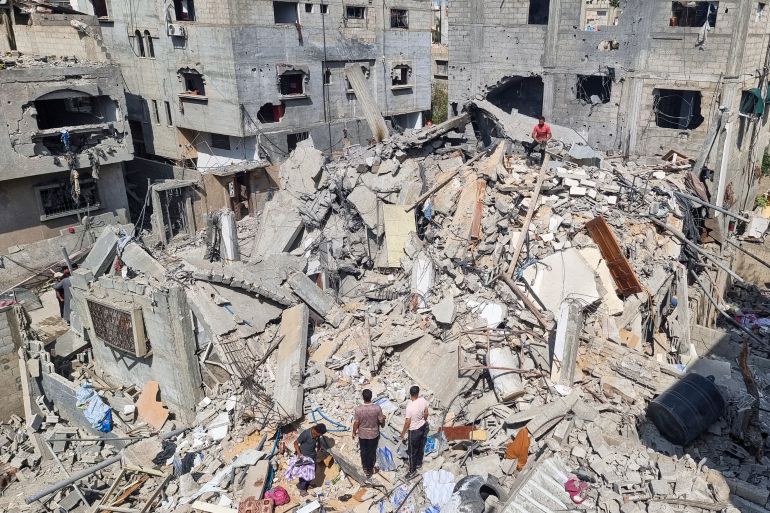 Palestinians look at the destruction after an Israeli airstrike in Rafah, Gaza Strip