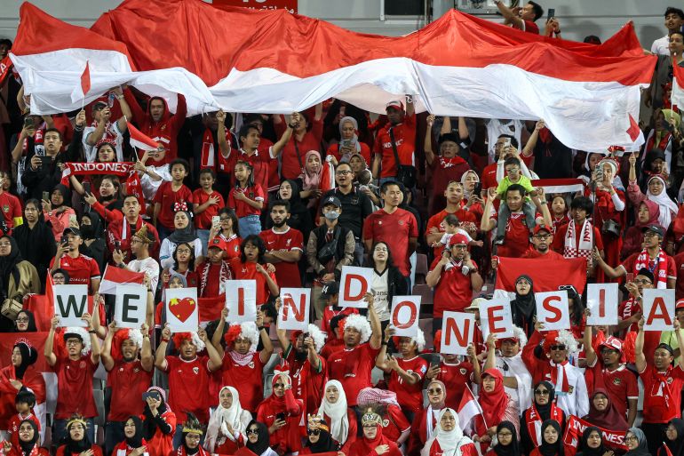 Indonesia's supporters cheer for their team in stadium.