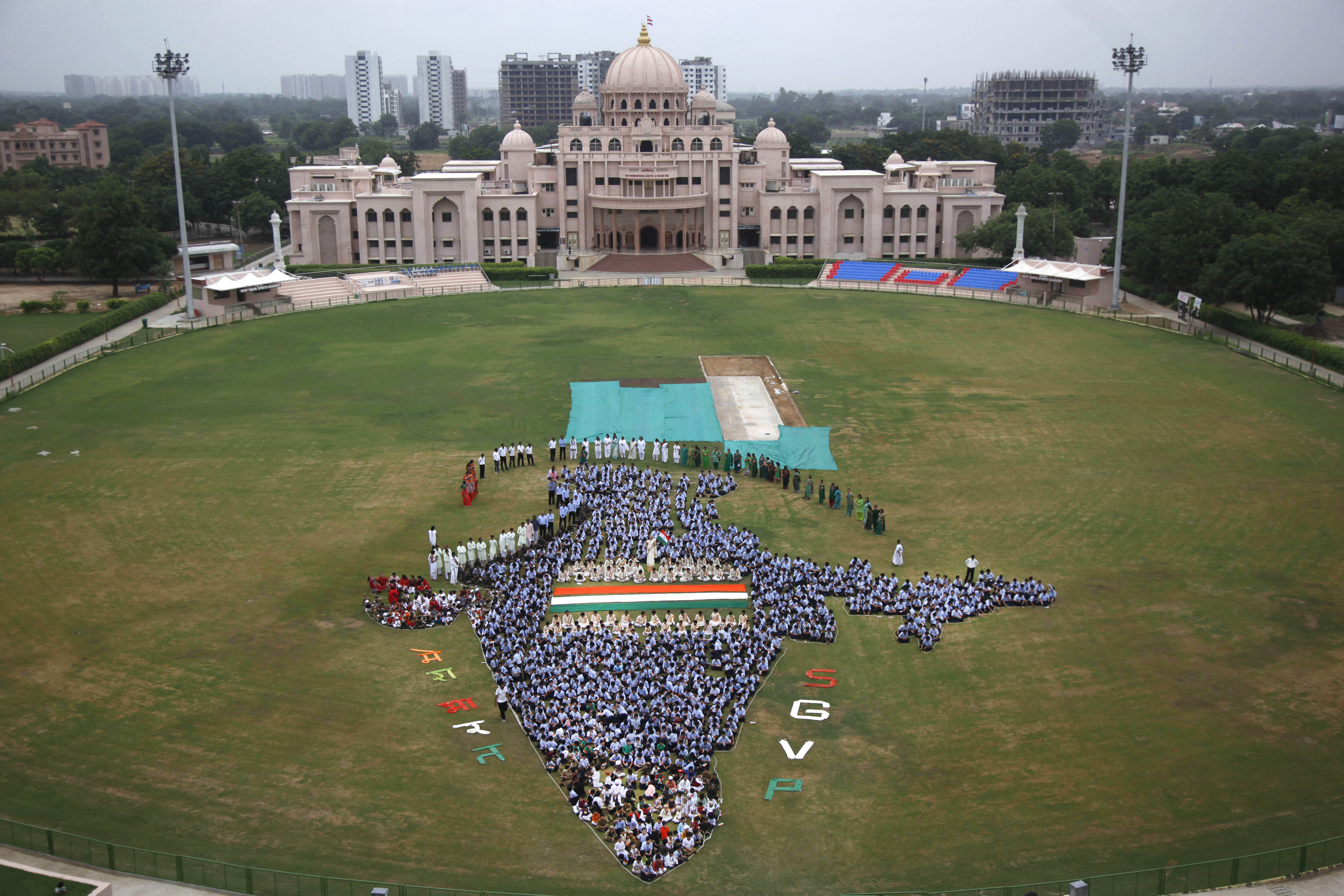 Indian students and teachers of Swaminarayan Gurukul form the map of India on the eve of Independence Day in Ahmadabad. [Ajit Solanki/AP]