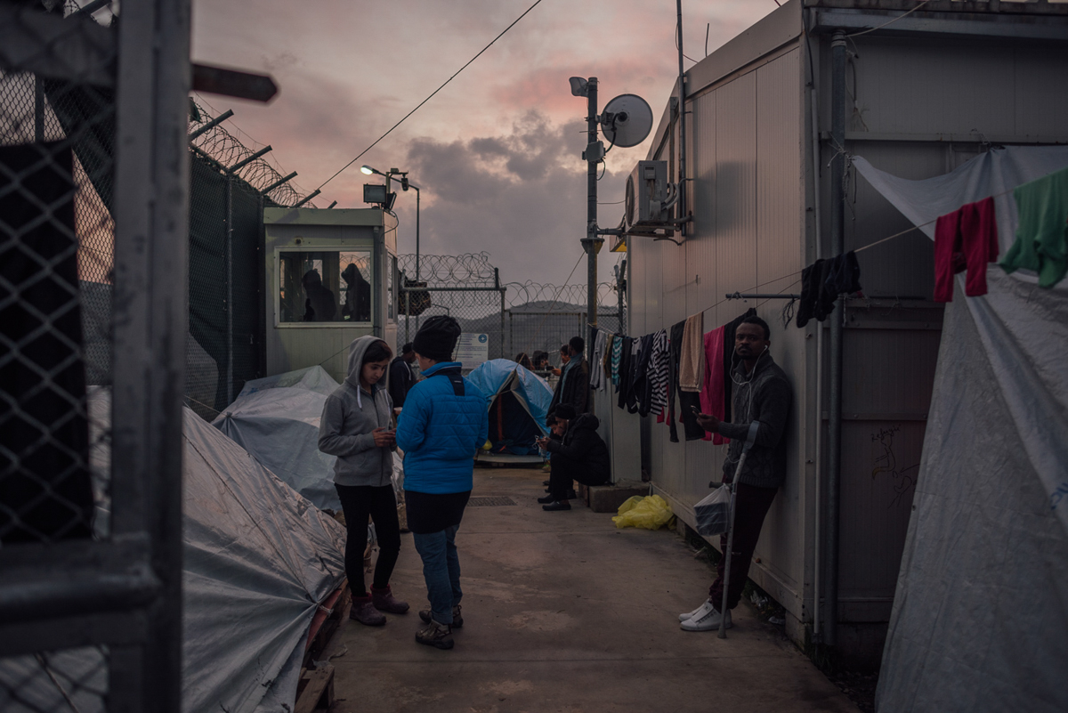 Asylum seekers gather around the only wifi-hotspot inside Moria camp. With just emergency cases allowed to travel to Greece's mainland, where conditions are generally better, many have to wait for more than 12 months until their claims are processed. [Kevin McElvaney/Al Jazeera]
