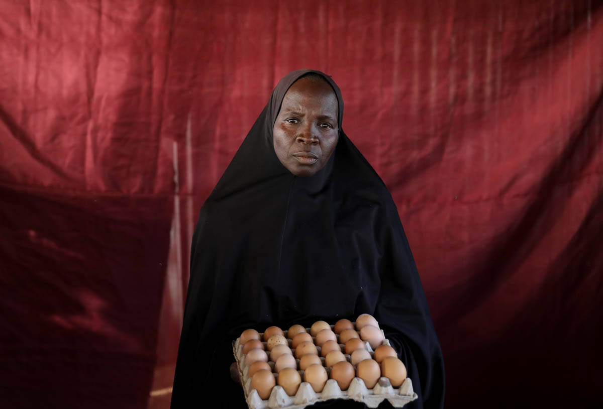 Famta Musa Tamaha holds a carton of eggs. [Afolabi Sotunde/Reuters]