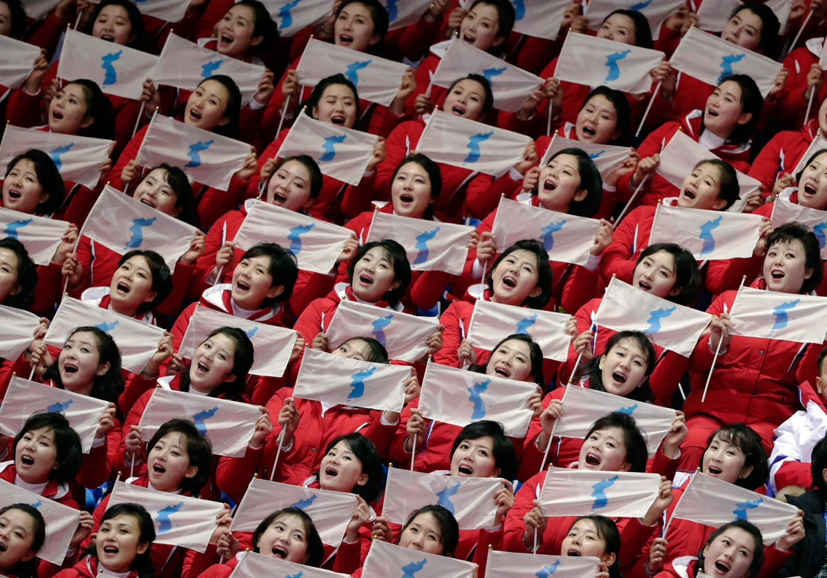 NorthKorean cheerleaders hold up Korean unification flags during the women's 500 metre short-track speedskating at the 2018 Winter Olympics in Gangneung, South Korea. [Julie Jacobson/AP Photo]