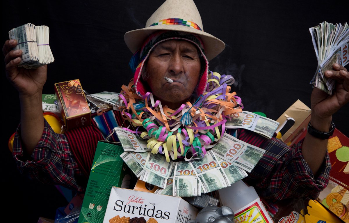 AlbertoMacias Rios, dressed as Ekeko, the god of prosperity and the central figure of the Alasita Fair, holds fake money as he poses for a portrait in La Paz, Bolivia. Macias, 65, says his short stature helps him pull off the Ekeko personality, which he's proud and happy to emulate. [Juan Karita/AP Photo]