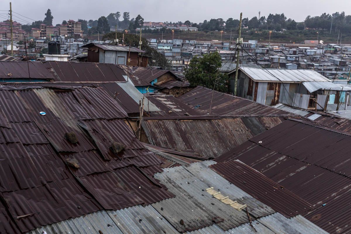 Most of houses in Kibera are made of mud and corrugated iron sheets that leak easily when it rains. Women use containers to drain the sewage water from their homes, a task that can take several hours or an entire day to complete. [Brian Otieno/Al Jazeera]