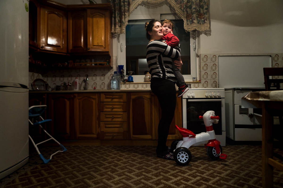 Tijana Lukic, who has two daughters and a son, in her kitchen with the son who made her proud in the eyes of her family. [Erik Messori/CAPTA/Al Jazeera]